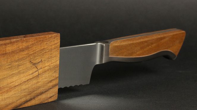 
                    The Caminada bread knife with sheath has a wooden handle
